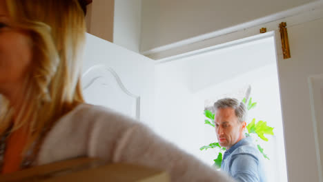 front view of mid adult caucasian couple entering with belongings in a comfortable home 4k