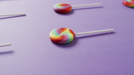 video of rows multicoloured lollipops on blue background