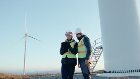 renewable energy engineers working with digital tablet at wind farm