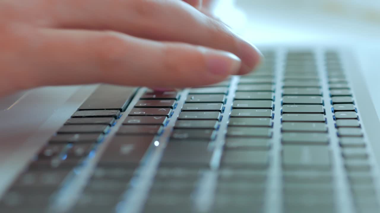 Close -up men's hands print the text on the laptop keyboard, a selective focus