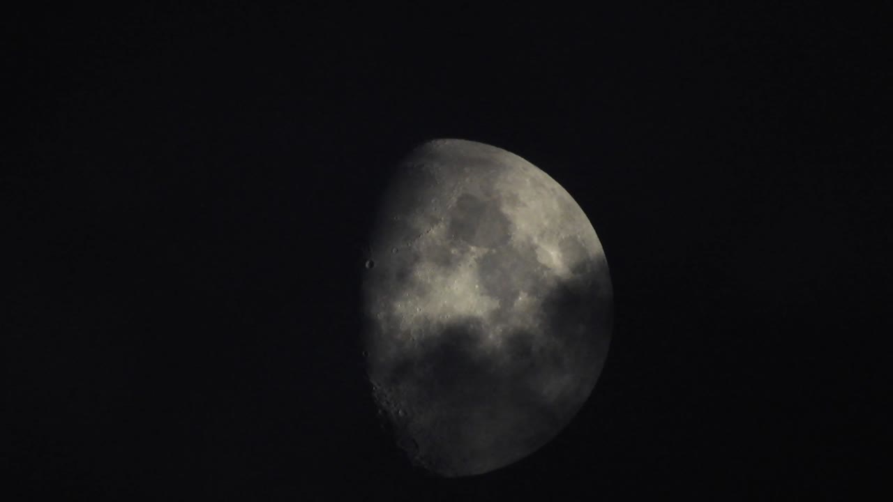 Moon at night with cloud real time. 4k video moon in the black sky.  Clouds passing by moon at night. night sky with cloudy weather