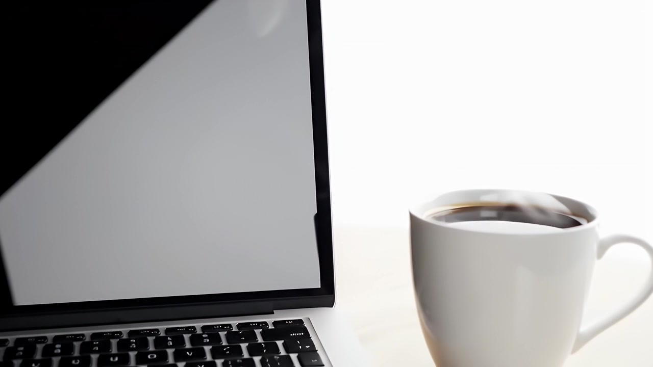 Laptop e tazza di caffè fumante su una scrivania