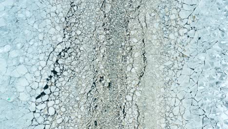 aerial fly over view of cracked ice floes floating in the sea