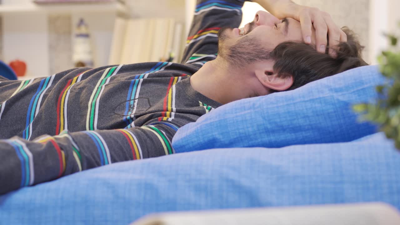 un joven llorando en su habitación y infeliz.