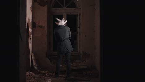 goat-mask figure in abandoned house