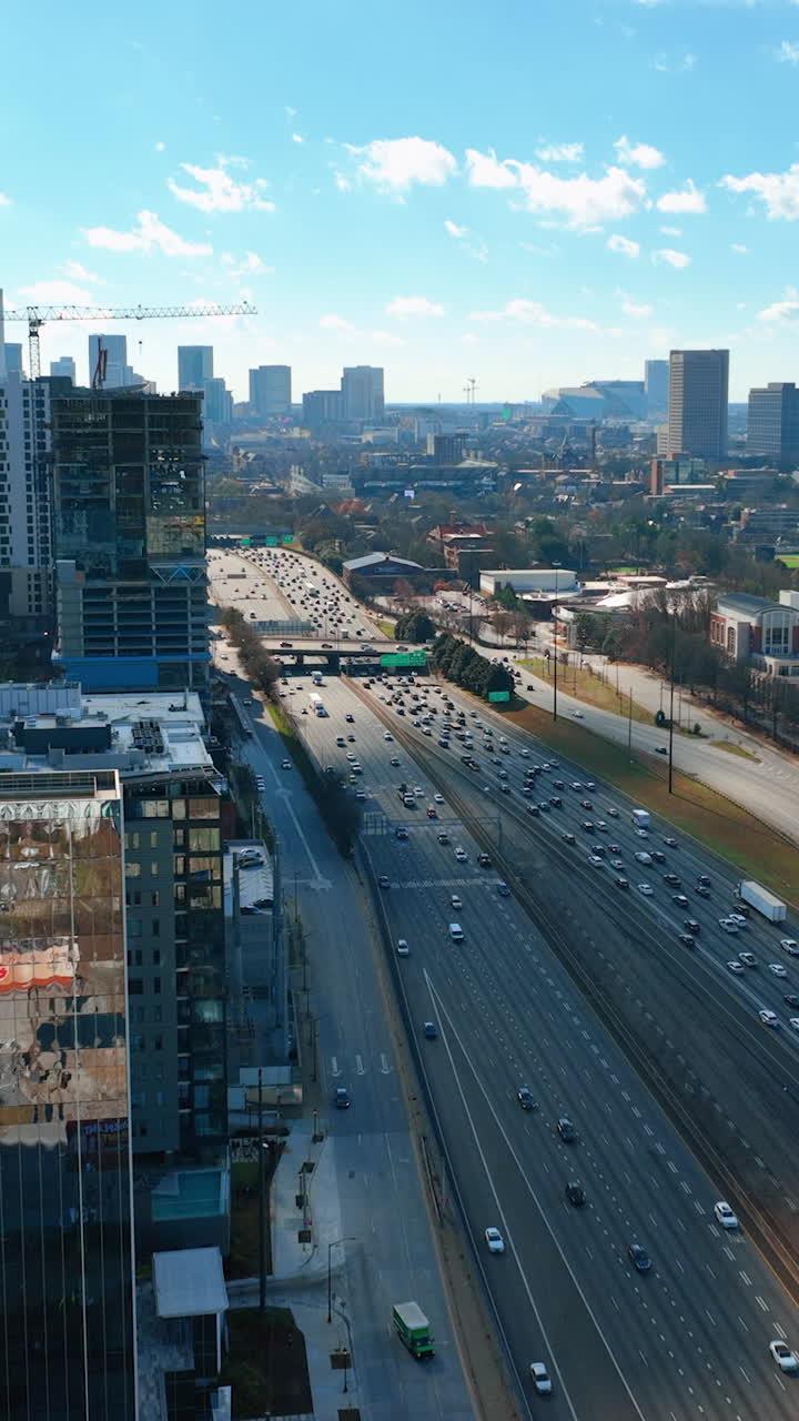 Downtown Atlanta Skyscrapers and Freeway. Business center with car traffic Interstate 85. Blue sky, autumn landscape. Aerial View Atlanta Buckhead. Vertical video