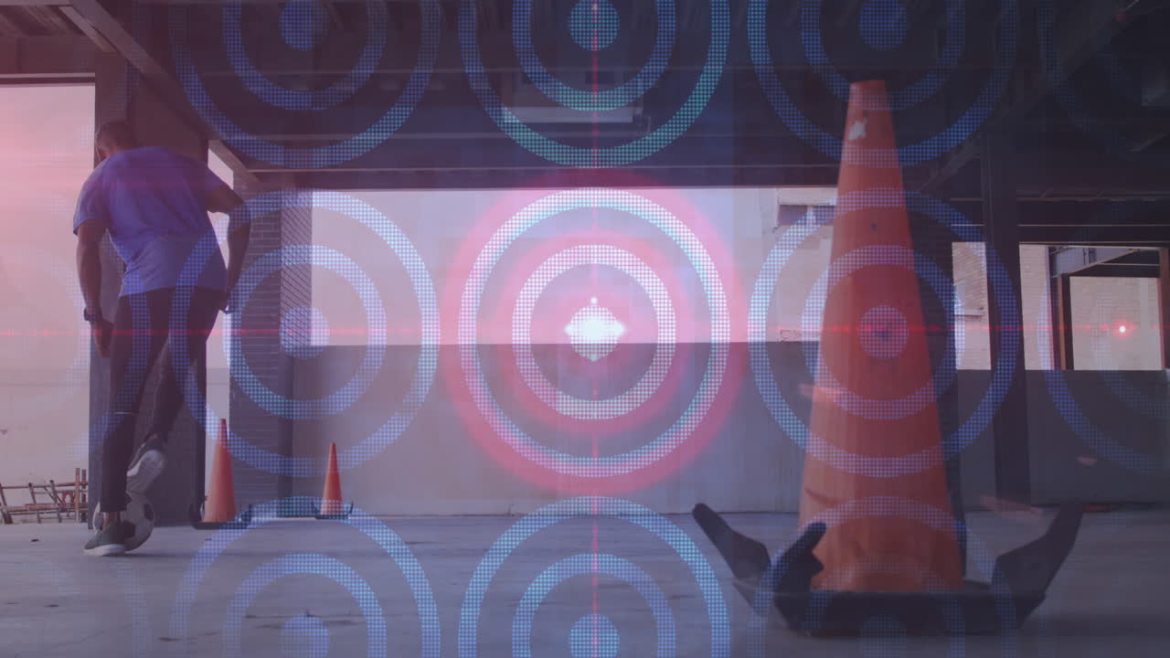 여러 개의 원형과 빛의 반점이 아프리카계 미국인 남자가 축구를 연습하는 것을 향해 움직이고 있습니다.