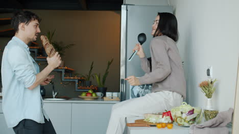 pareja cantando y bailando en la cocina