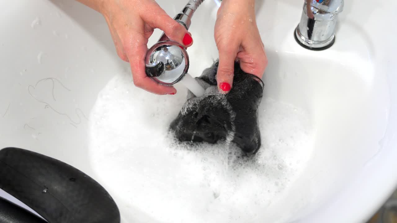 Washing a wig in a basin