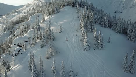 aéreo de drone hombre esquiador esquiando en las montañas nevadas cuesta arriba en una línea