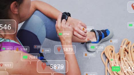 animation of media icons over caucasian woman with smartwatch on climbing wall