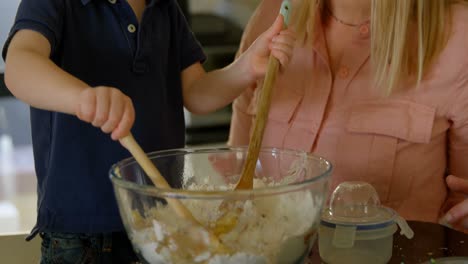 Happy-mother-and-son-mixing-flour-in-kitchen-4k