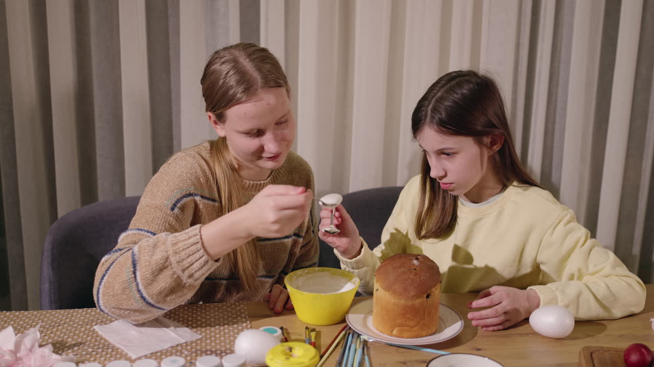 Sisters decorating Easter bread and eggs
