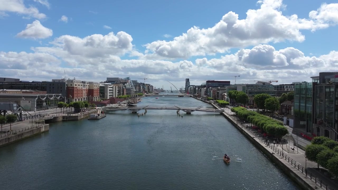 Trafikk og fotgjengere langs den sentrale havnefronten mens en drone trekker seg tilbake langs elvekorridoren Dublin June26 under lette skyer