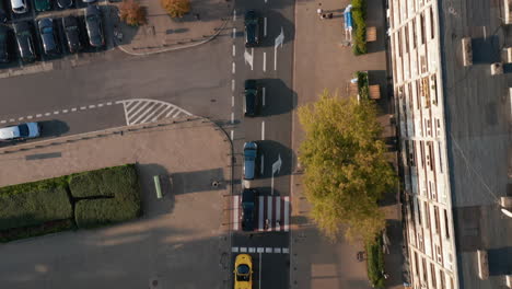 Aerial-birds-eye-overhead-top-down-panning-view-of-cars-stopping-in-queue-before-crossroads.-Warsaw,-Poland