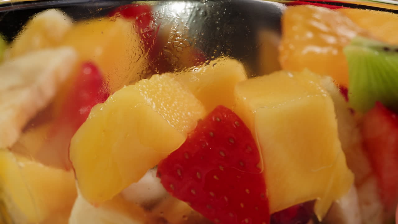 Close-up of Fresh Colorful Mixed Fruit Salad Being Stirred