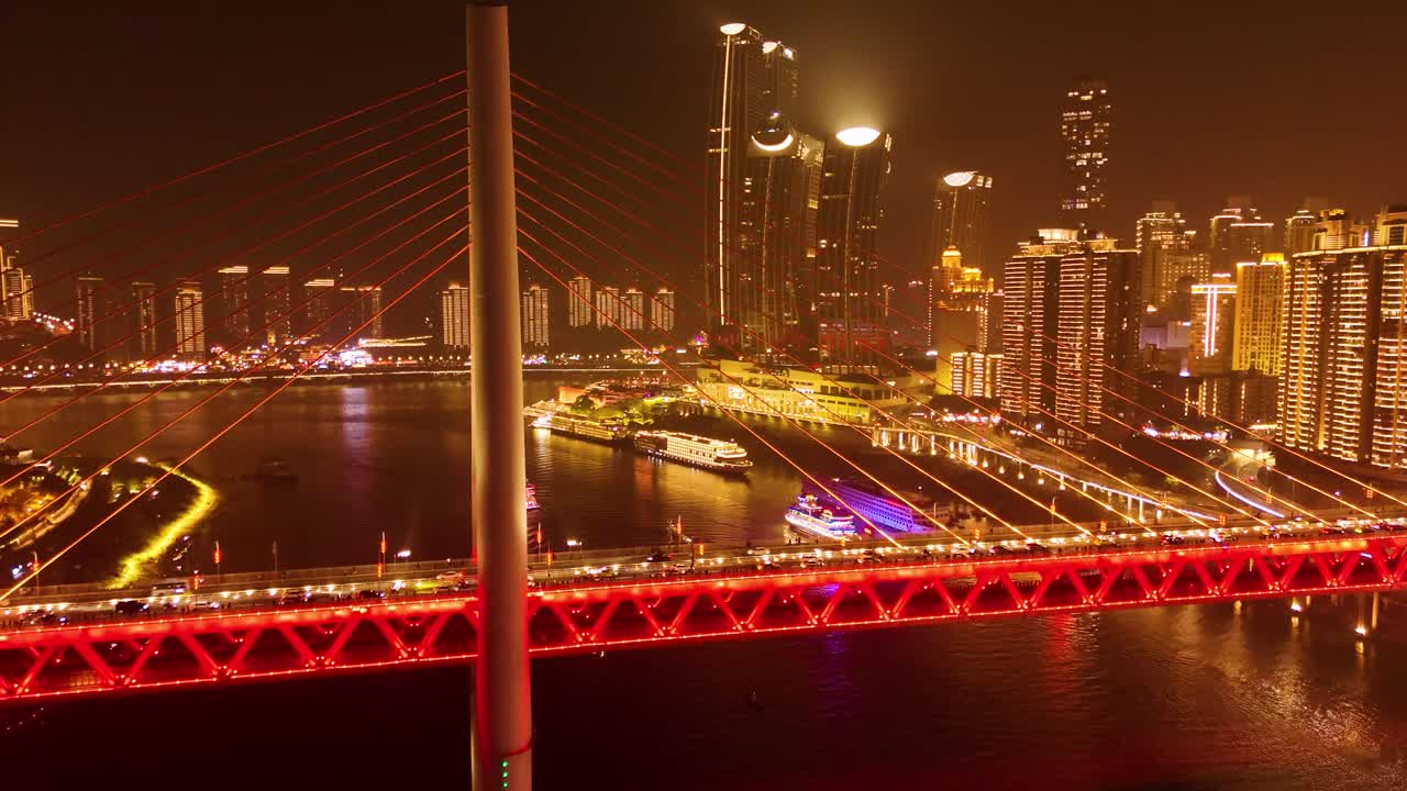 Aerial: Twin River Bridges at night in Chongqing with cityscape and skyscrapers, Yuzhong District, China, crane down drone shot