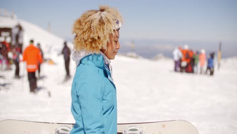 joven de moda llevando su snowboard