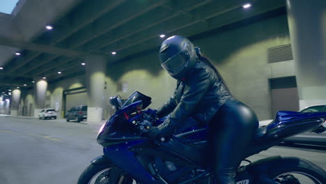 the camera pans around a woman sitting on a motorcycle in downtown los angeles