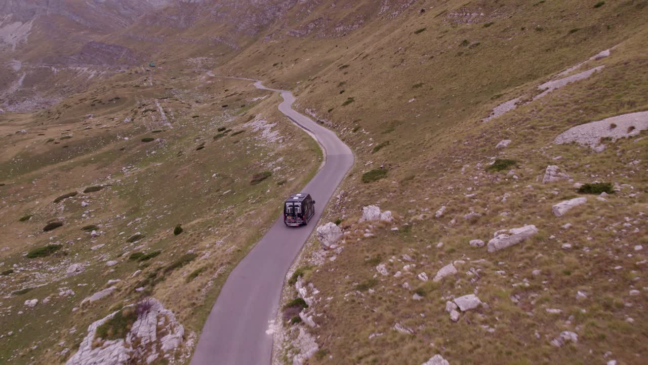 Ripresa aerea che rivela un camper che guida su strada nel Parco Nazionale del Durmitor, Montenegro