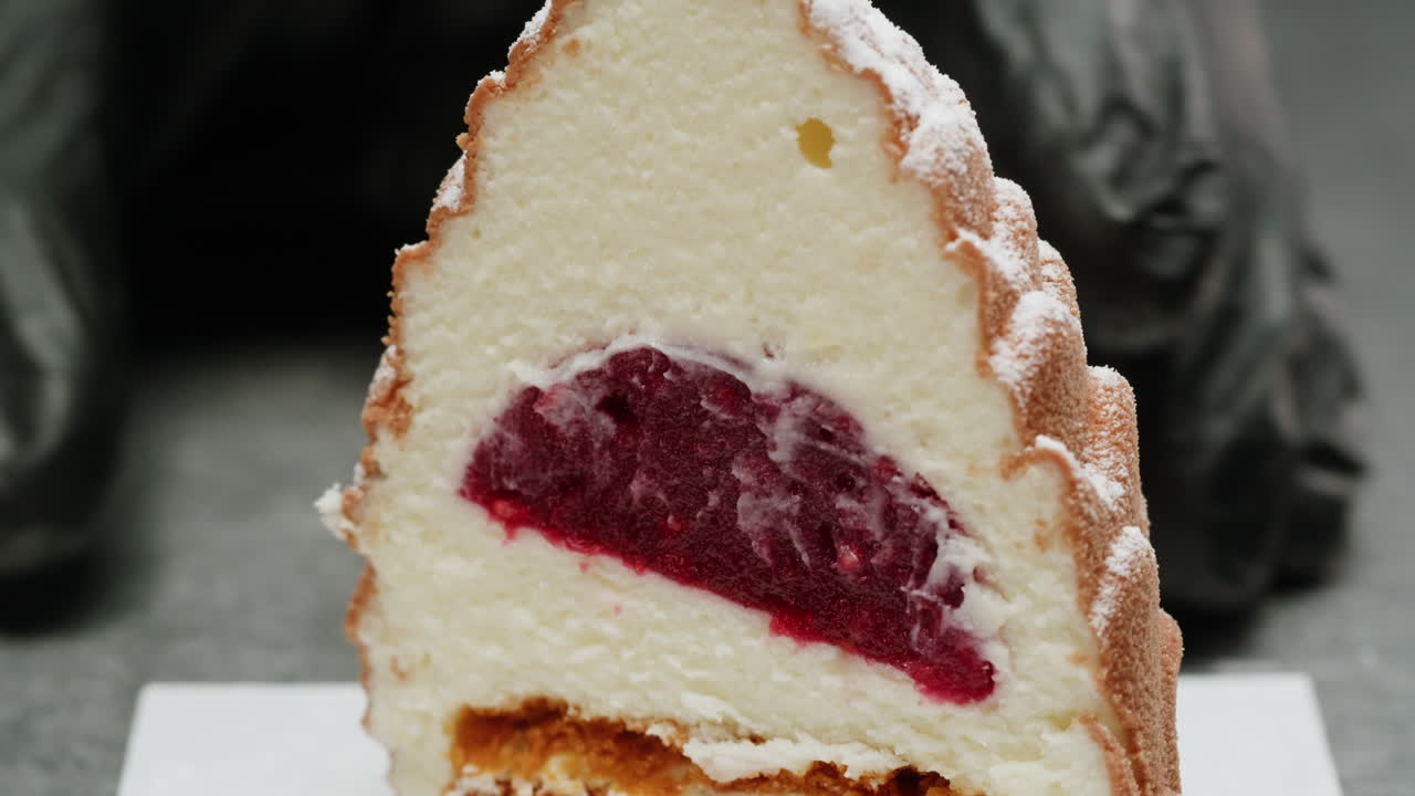 Close-up of a sliced dessert cake with berry filling