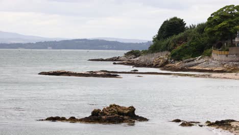 rocky shoreline with distant hills and calm sea