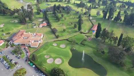 Vista-Aérea-Del-Campo-De-Golf-Con-Hermoso-Lago-Y-Estacionamiento