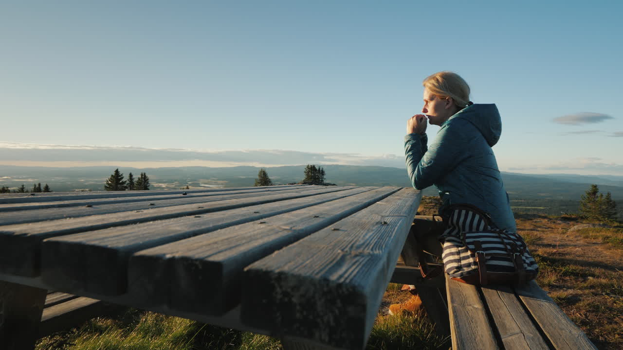 A Lonely Middle-Aged Woman Sitting At A Table High In The Mountains Prays 4k Video