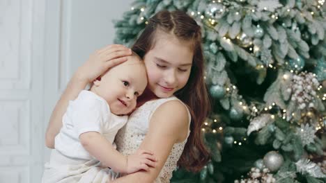 portrait of happy siblings near christmas tree in modern house.