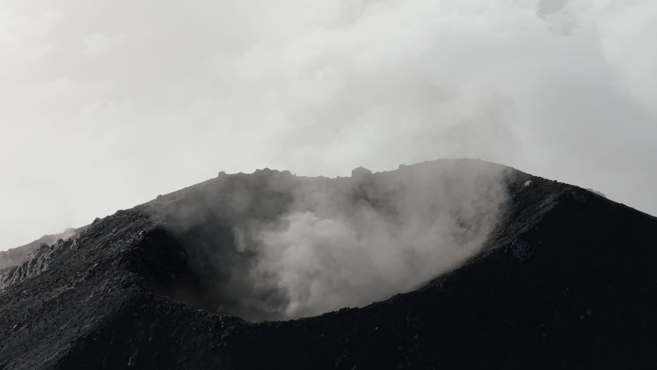 Imagem aérea orbital da borda da cratera do Vulcão Fuego na Guatemala, com vapor a subir do interior.