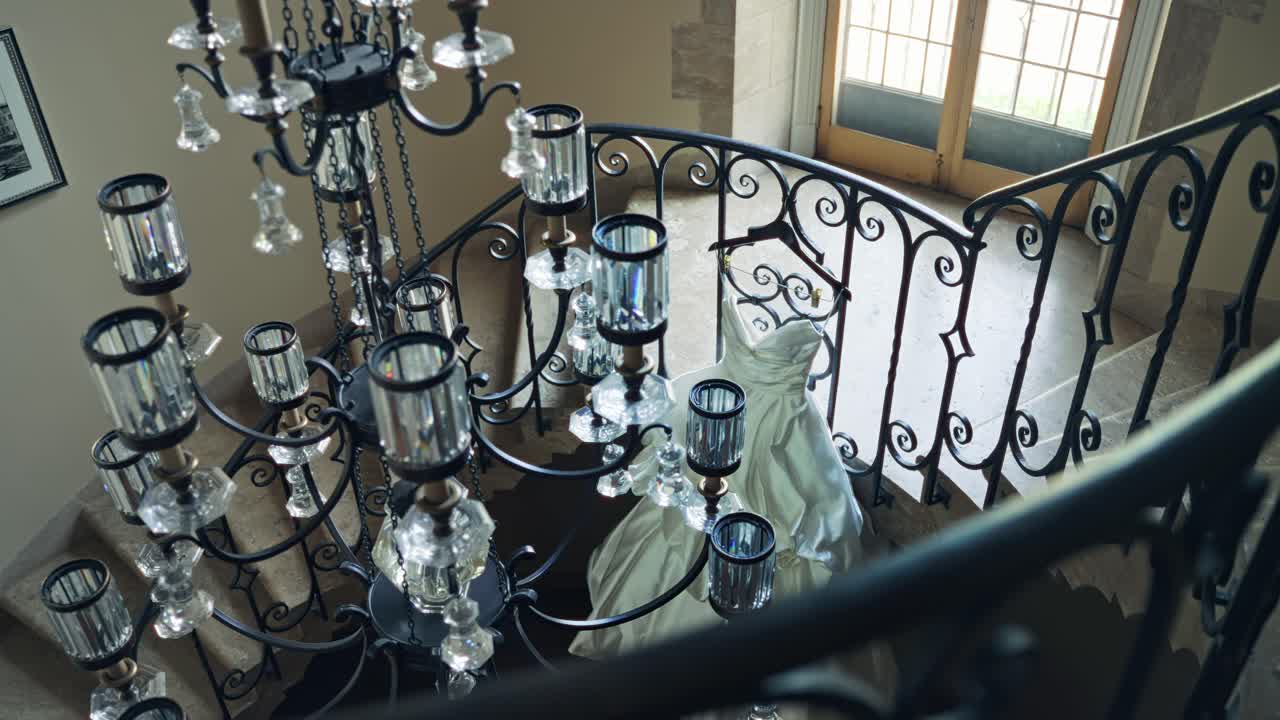 화려한 화려한 웨딩 드레스가 나선형 계단에 전시되어 있습니다. 우아한 설정, 유리 들리어를 통해 상공을 볼 수 있습니다.