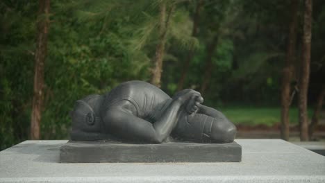 a statue of a person lying down with crossed legs