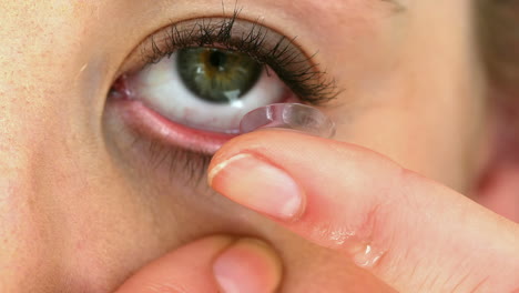 woman about to insert her contact lens