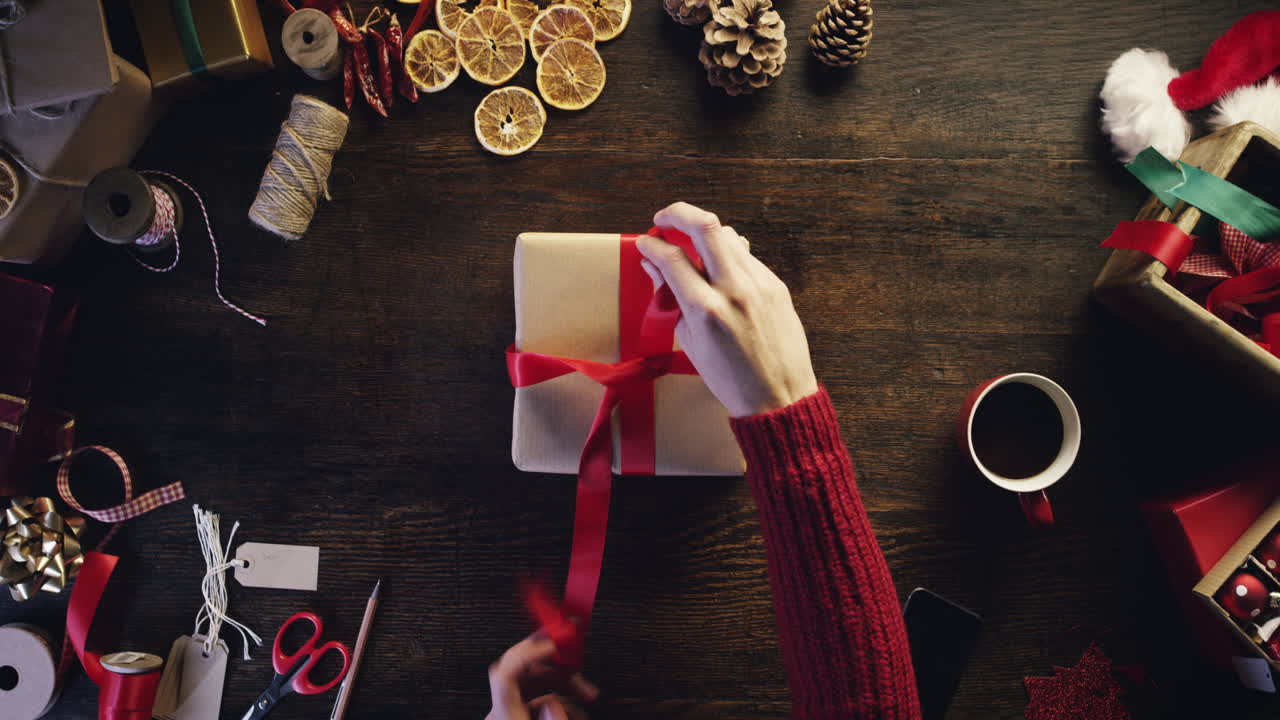vista superior manos envolviendo regalos de navidad en un escritorio de madera desde arriba - dragón épico rojo