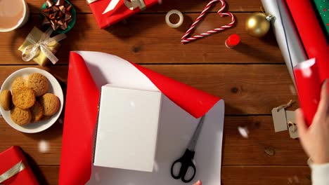 Hände-Verpacken-Weihnachtsgeschenkboxen-Mit-Papier.-Weihnachtsgeschenke-Verpacken.-Weibliche-Hände-Verpacken-Weihnachtsgeschenkboxen-Mit-Papier.-Tischansicht,-POV.