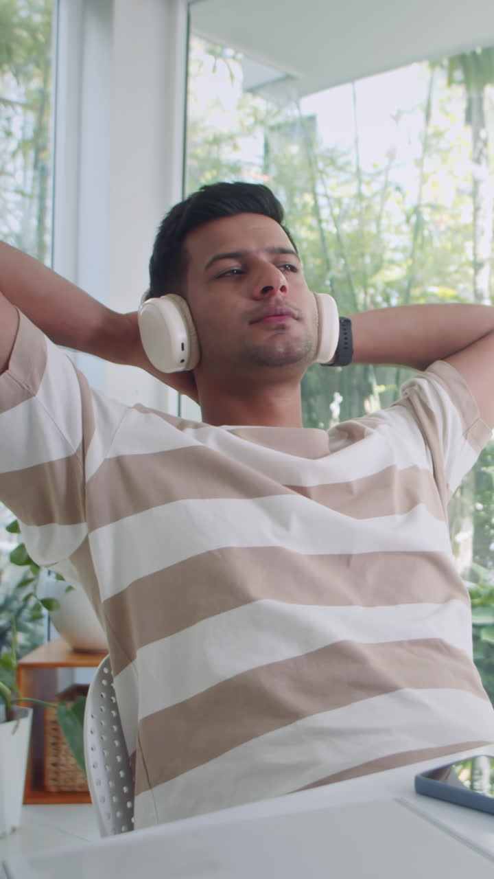 Uomo che si rilassa su una sedia e si lascia trasportare dalla musica con le cuffie