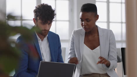 african american business woman team leader brainstorming with colleague using laptop computer showing ideas pointing at screen working together in office