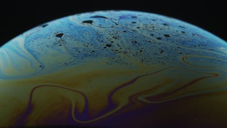 line streaks on surface of soap bubbles in multiple colors: macro abstract shot