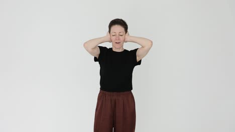 woman covering ears due to loud noise