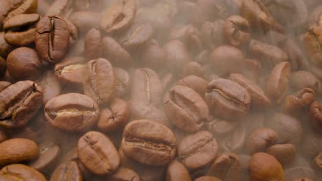 Close-up-of-seeds-of-coffee.-Fragrant-coffee-beans-are-roasted-smoke-comes-from-coffee-beans.