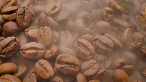 cerca de las semillas de café. los granos de café perfumados son tostados el humo viene de los granos de café.