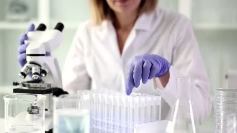 a scientist working in a laboratory with test tubes and a microscope