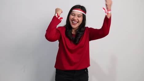young asian woman celebrates indonesia independence day, showing fist hand isolated over white background