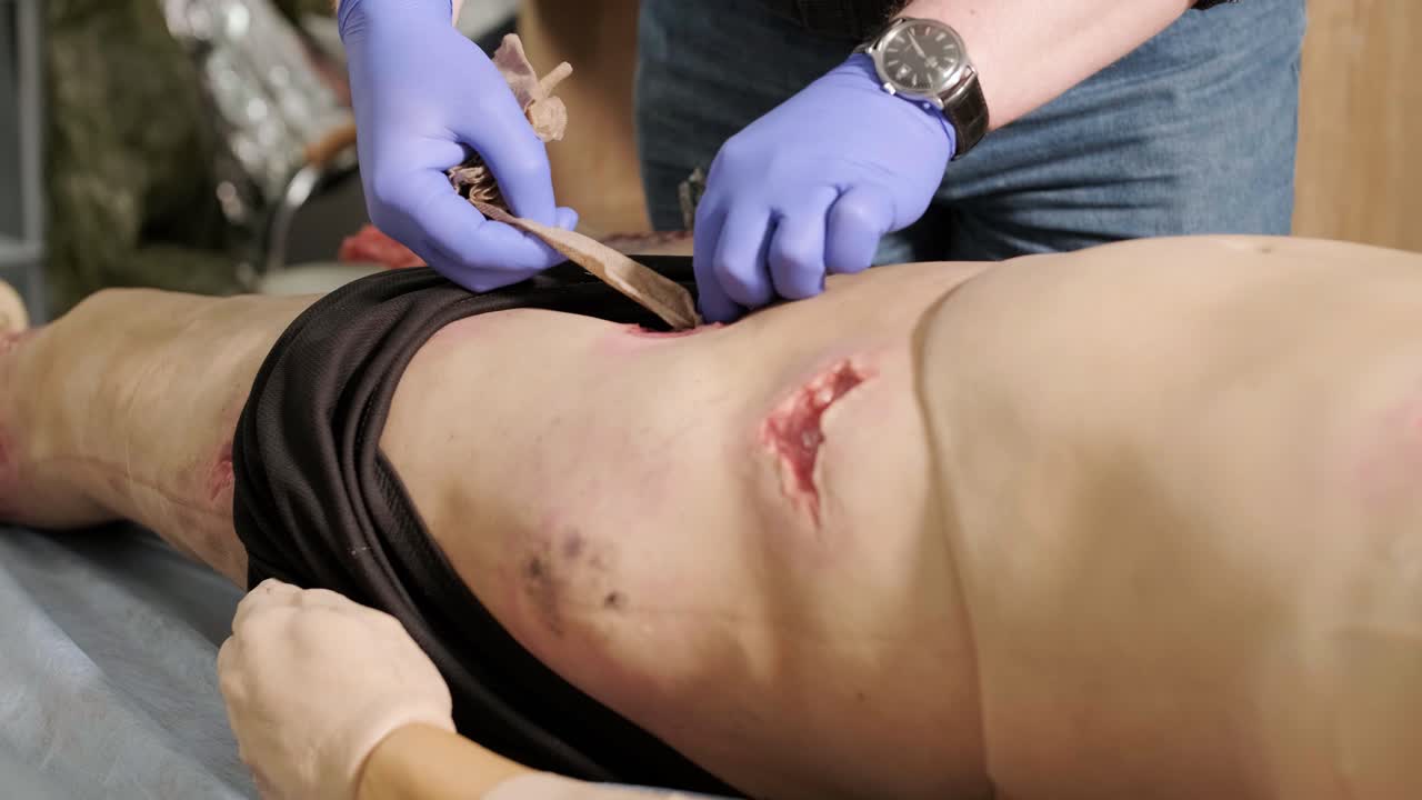 전술 의료진은 마네킨의 총상으로 인한 출혈 통제를 수행합니다.