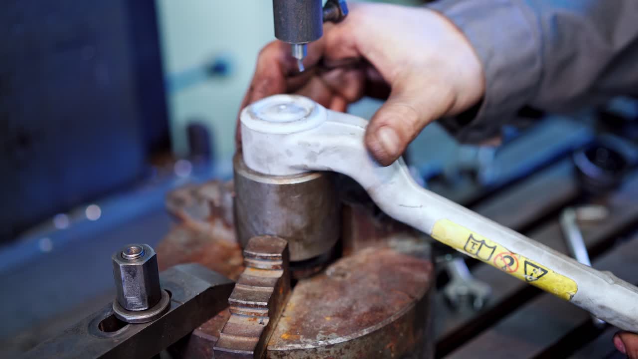 Man working in industry factory. Engineer with handtool doing his work by huge industrial machine in factory