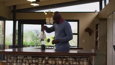 African-american-senior-man-in-kitchen-making-coffee-in-pot