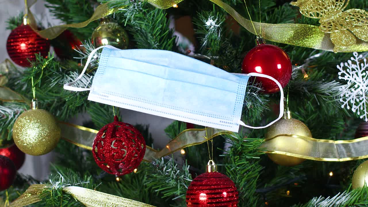 코로나19 예방을 위해 크리스마스 트리에 손으로 마스크를 착용하십시오.