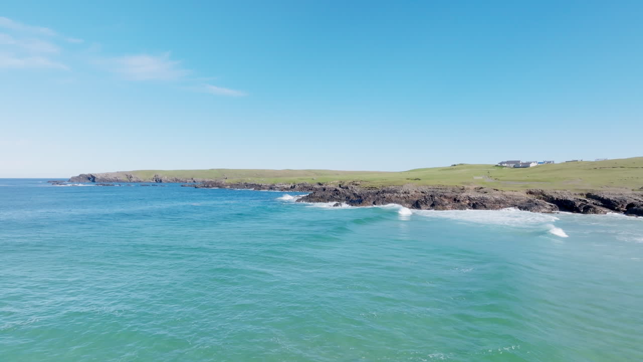 Eoropie Beach on the Isle of Lewis in the Outer Hebrides, Scotland. Clear turquoise water meets rocky coastline under bright blue skies, showcasing the wild beauty of the Scottish isles