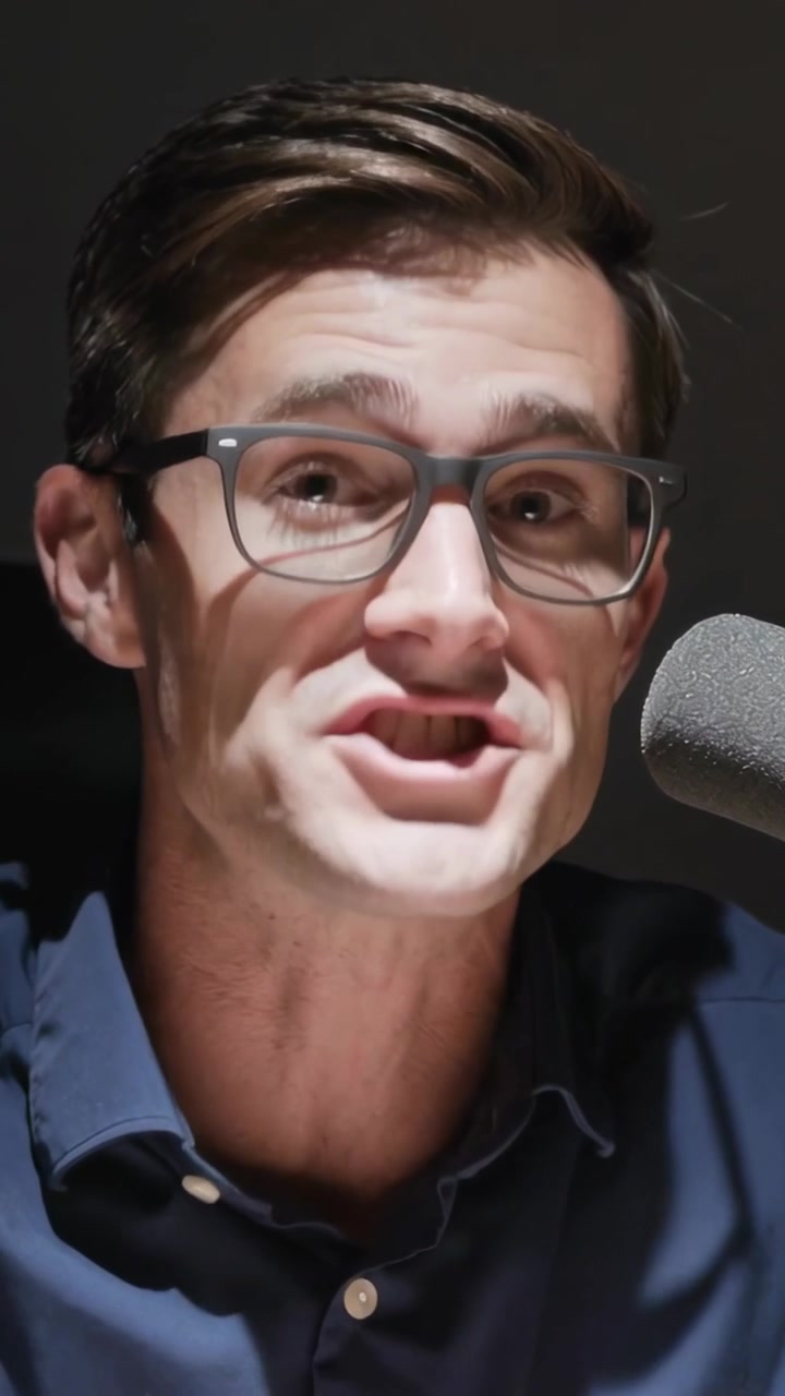 Video verticale: Uomo in camicia blu scuro che risponde a una domanda di intervista parlando al microfono in studio.