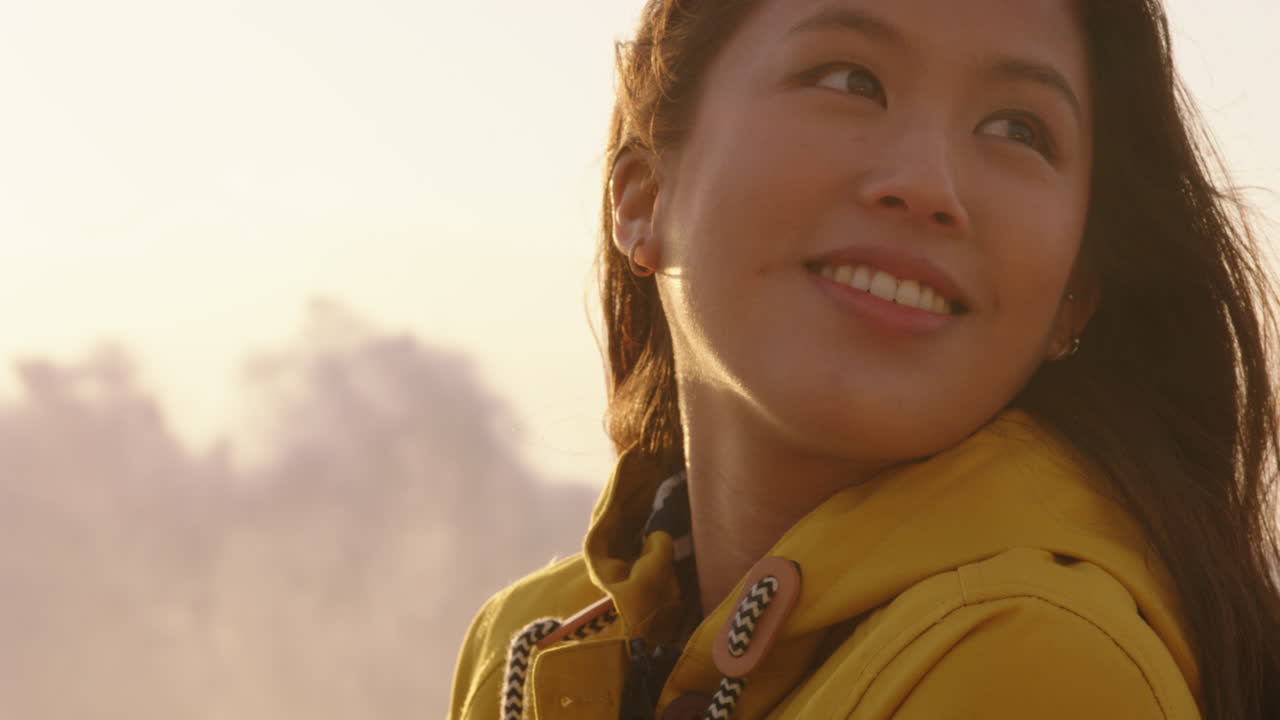 portrait of beautiful asian woman enjoying seaside at sunset exploring spirituality looking up praying contemplating journey relaxing on beach